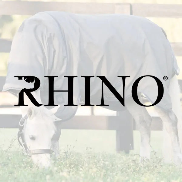 White horse wearing a white blanket with 'RHINO' logo in the foreground